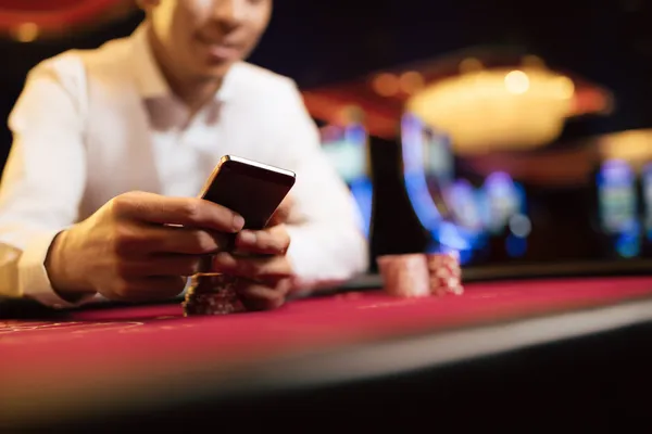 A young woman relaxing with her phone while dynamic casino elements float around her, illustrating the smooth mobile experience offered by the 88DF app.